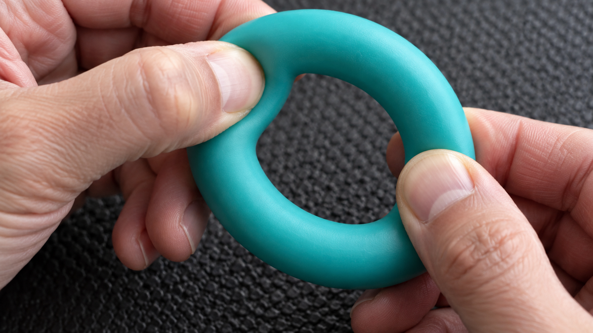An adult gently pressing a flexible puppy toy to show how its material yields.