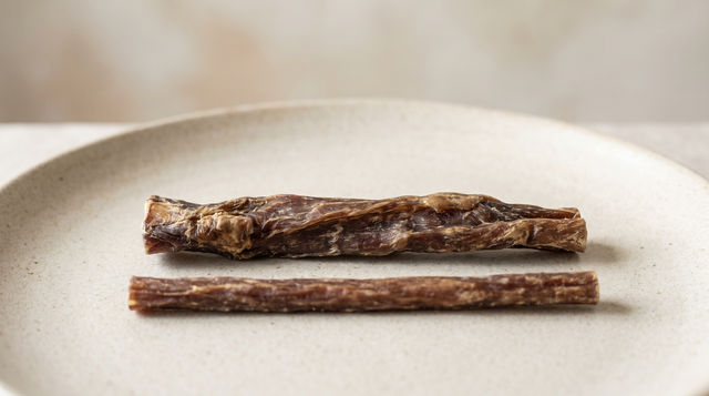 Two plain dried beef chew sticks lying side by side, one noticeably thicker than the other